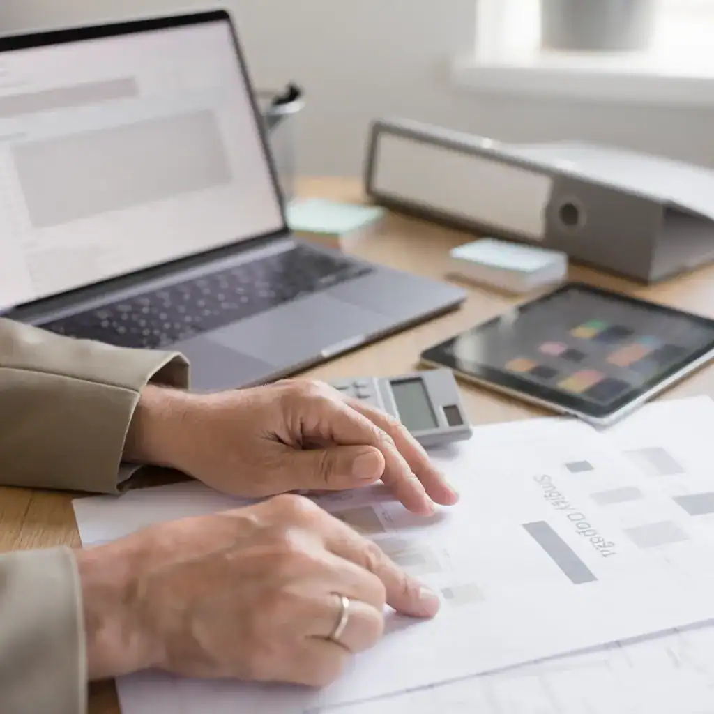 Espace de travail avec ordinateur portable, tablette et documents.